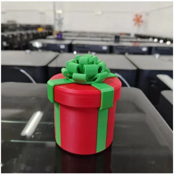 Red cylindrical Christmas gift box with green ribbon and bow - 3D printed matryoshka nesting decor