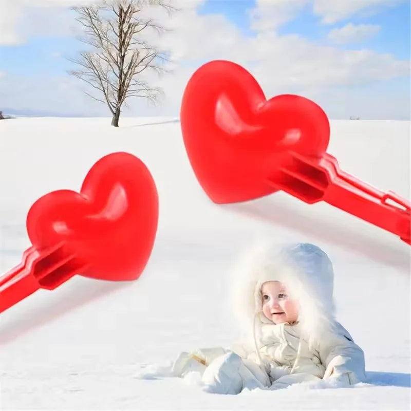 Red heart snowball clip mold placed on snowfield background in daylight