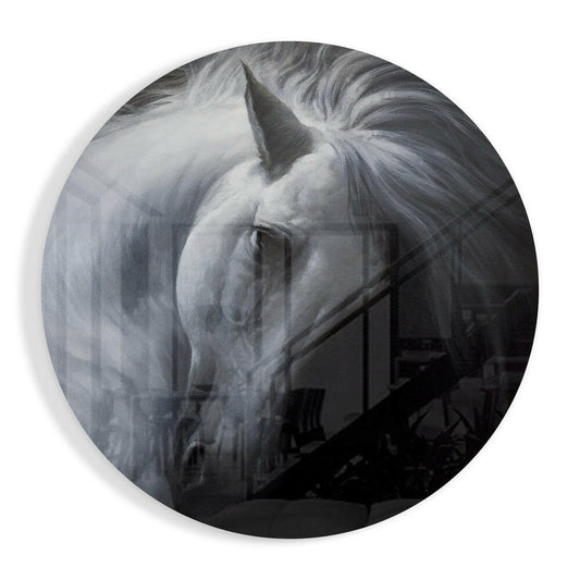 Round glass disc with a black and white photo of a white horse bowing its head, long mane falling across a dark background