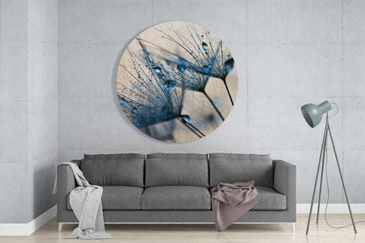 Blue dewdrop dandelion seeds round glass wall art above a gray sofa beside a tripod floor lamp