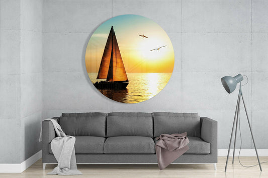 Sunset sailboat round glass wall art above a gray sofa with a tripod floor lamp in a living room
