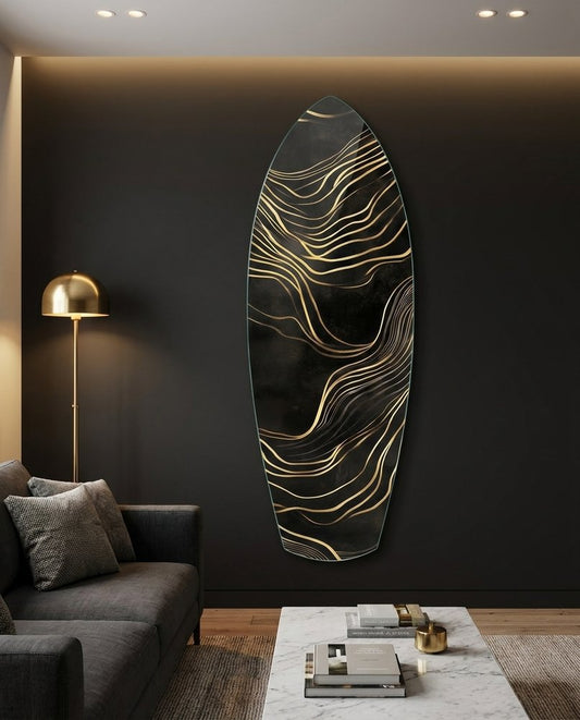 Black and gold flowing lines surfboard glass wall art on a dark wall above a gray sofa beside a brass floor lamp