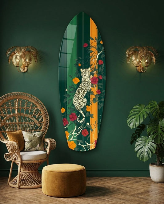 Leopard surfboard glass wall art on a dark green wall beside a rattan peacock chair and gold palm sconces