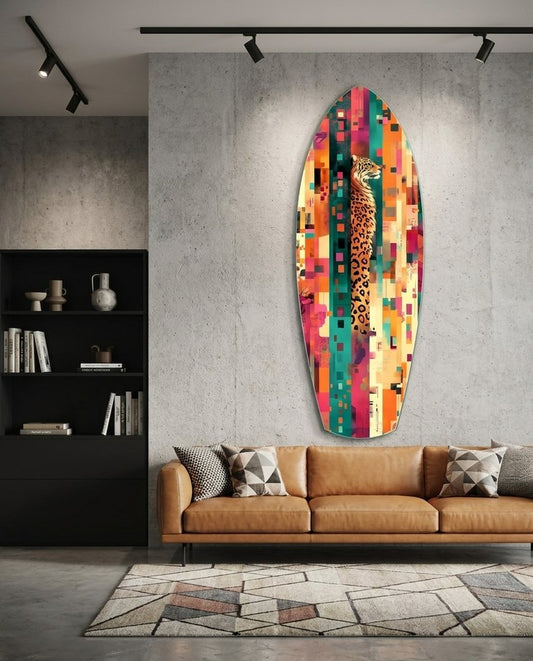 Leopard surfboard glass wall art on a concrete wall above a tan leather sofa under black track lights
