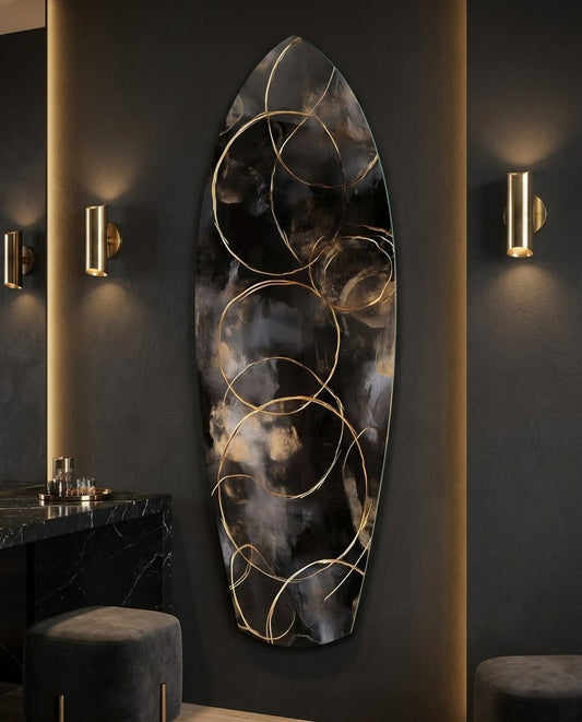 Black and gold surfboard glass wall art on a dark wall between brass sconces beside a black stone counter