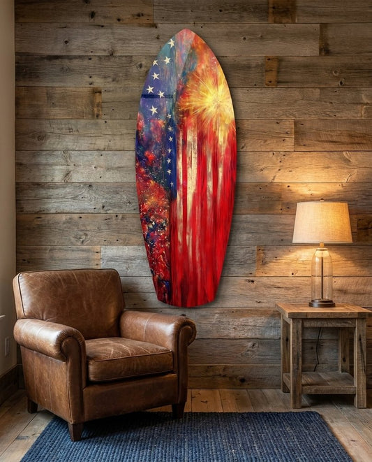 Flag fireworks surfboard glass wall art on a reclaimed wood wall above a brown leather armchair and a table lamp