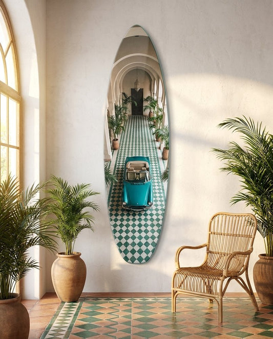 Vintage convertible surfboard glass wall art in an arched sunroom with green checkered tiles and potted palms