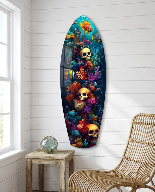 Coral reef skulls surfboard glass wall art on a white shiplap wall beside a rattan lounge chair and a globe
