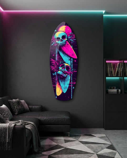 Neon Surfing Skulls surfboard glass wall art in a dark gray lounge with a black sectional sofa and neon ceiling light