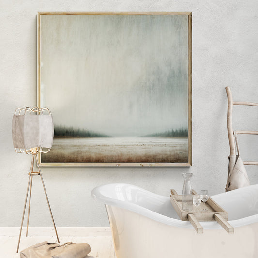 Square canvas of a pale gray misty sky over a thin dark treeline and frosted ground, hung above a freestanding bathtub