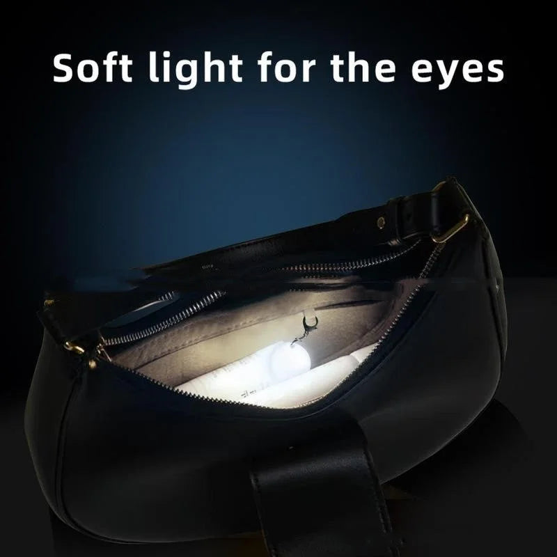 Soft white heart pendant light illuminating inside zippered handbag