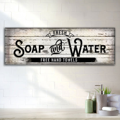 Long canvas bathroom sign with black vintage Soap and Water lettering on a worn white wood look, on a white tile wall