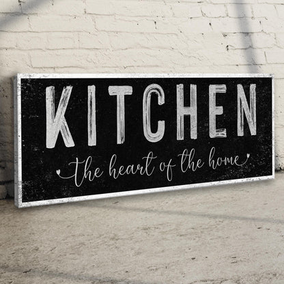 Kitchen Heart of the Home Black canvas seen at an angle on a brick wall above a wood floor, view 3