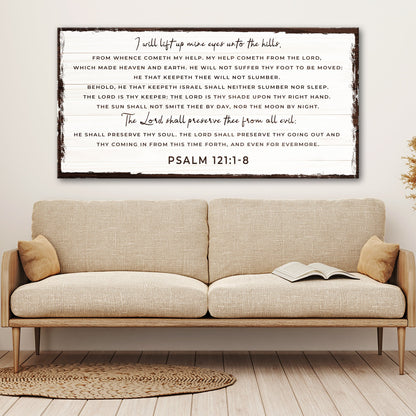White plank-look canvas sign with Psalm 121:1-8 in dark script and capitals, dark worn edge, above a beige sofa