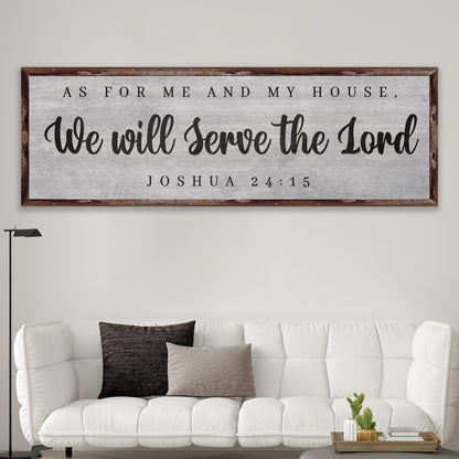 Joshua 24:15 We Will Serve the Lord canvas sign, gray with a dark wood-look border, above a white sofa