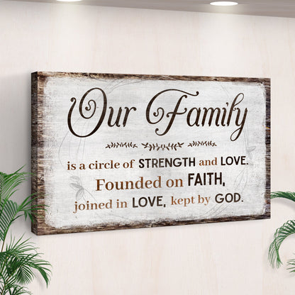 Our Family canvas sign with a saying about strength, love and faith on rustic white, seen at an angle by a palm