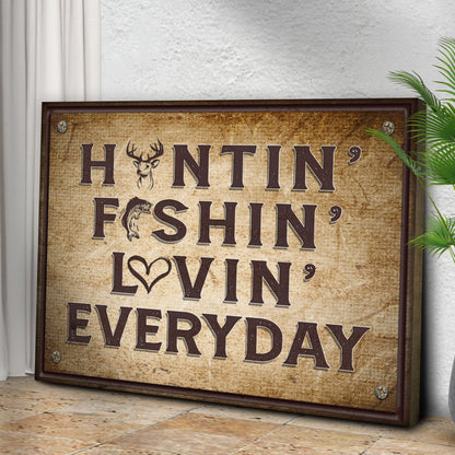Huntin' Fishin' Lovin' Everyday canvas sign leaning on a stone floor beside a green palm plant