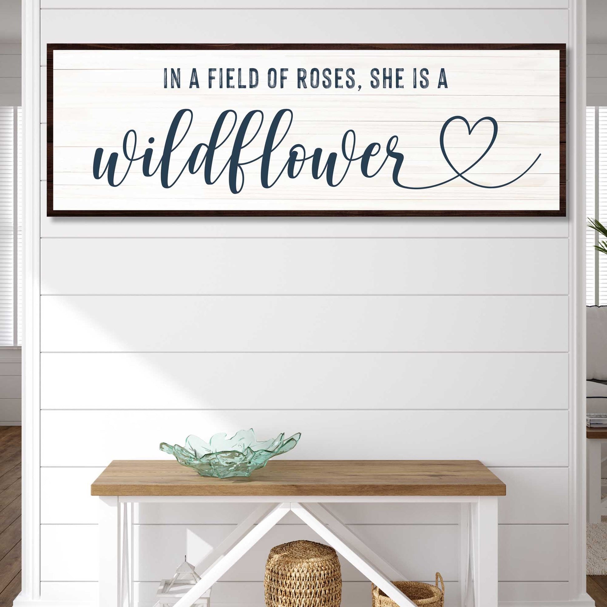 She Is A Wildflower motivational canvas sign hanging on a wall