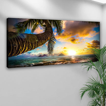 Palm tree beach sunset canvas on a white wall beside a green plant, angled view