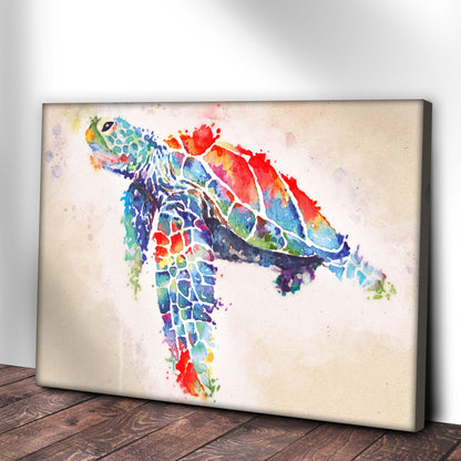 Rainbow watercolor-look sea turtle canvas leaning against a white wall on a wood floor, angled view