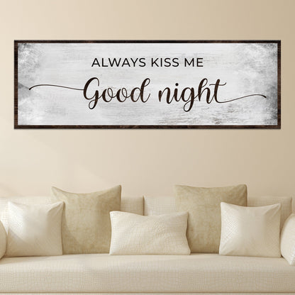 Always Kiss Me Good Night canvas sign in the gray style, hung above a cream sofa with pillows