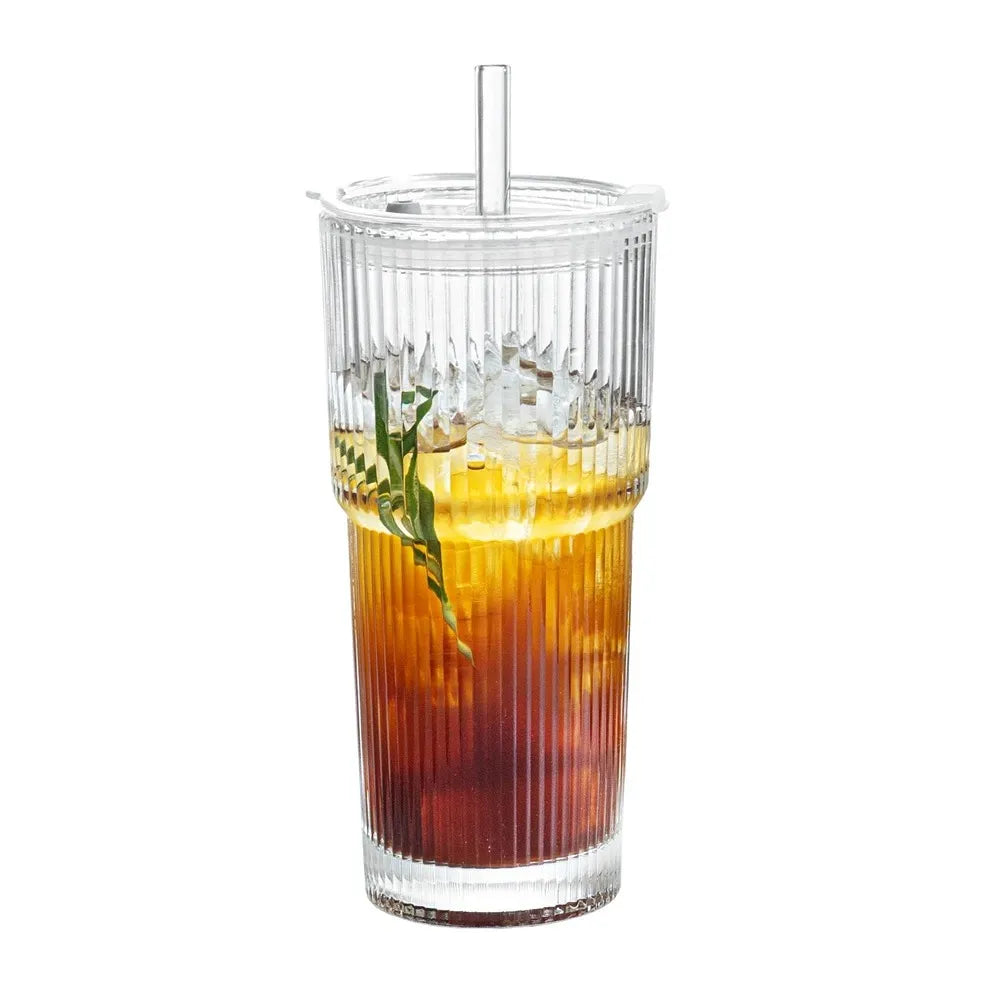 Transparent glass cup showing colorful layered beverage with lid on