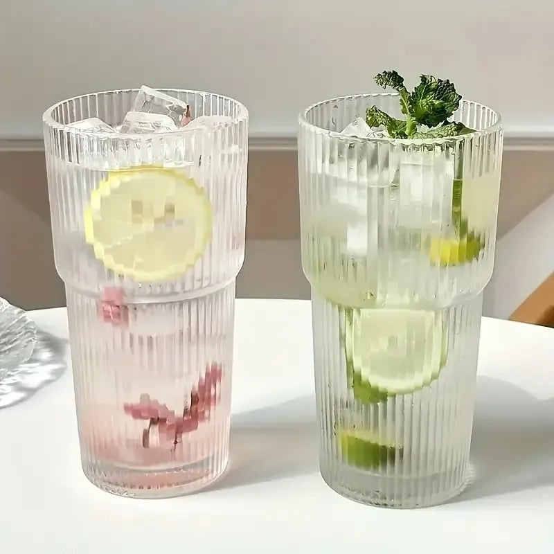 Two striped glass tumblers filled with different drinks