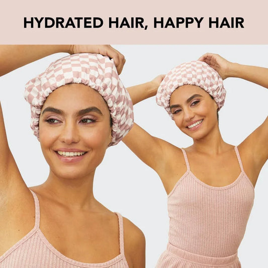 Two women wearing pink checkered shower caps demonstrating hydrated hair protection after shower