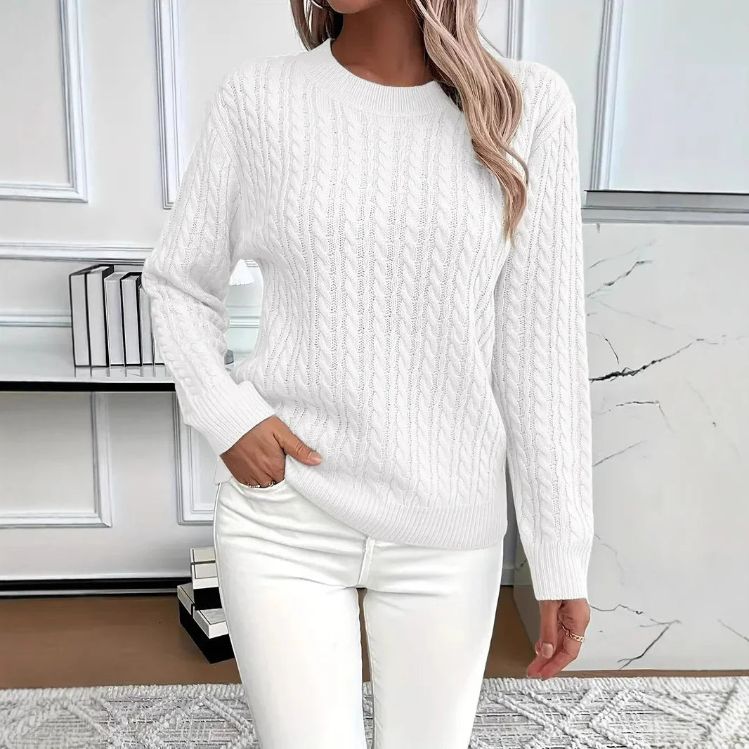White cable-knit women’s pullover sweater paired with white denim for a clean, elegant look