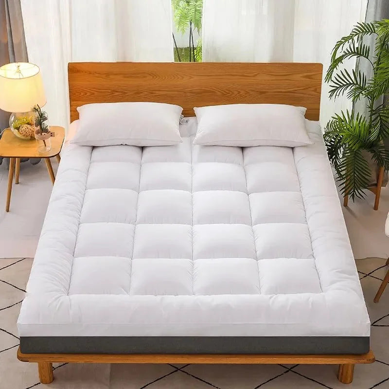 White mattress topper pad displayed on bed with wooden frame and pillows
