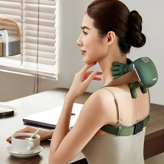 Woman using an electric neck and shoulder massager while sitting at a desk.