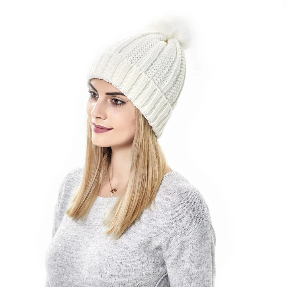 Woman wearing Cable knit beanie with paisley satin lining and fluffy faux fur pompom detail in white