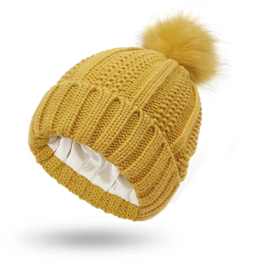 Yellow cable knit beanie with silk satin interior lining protects hair from frizz