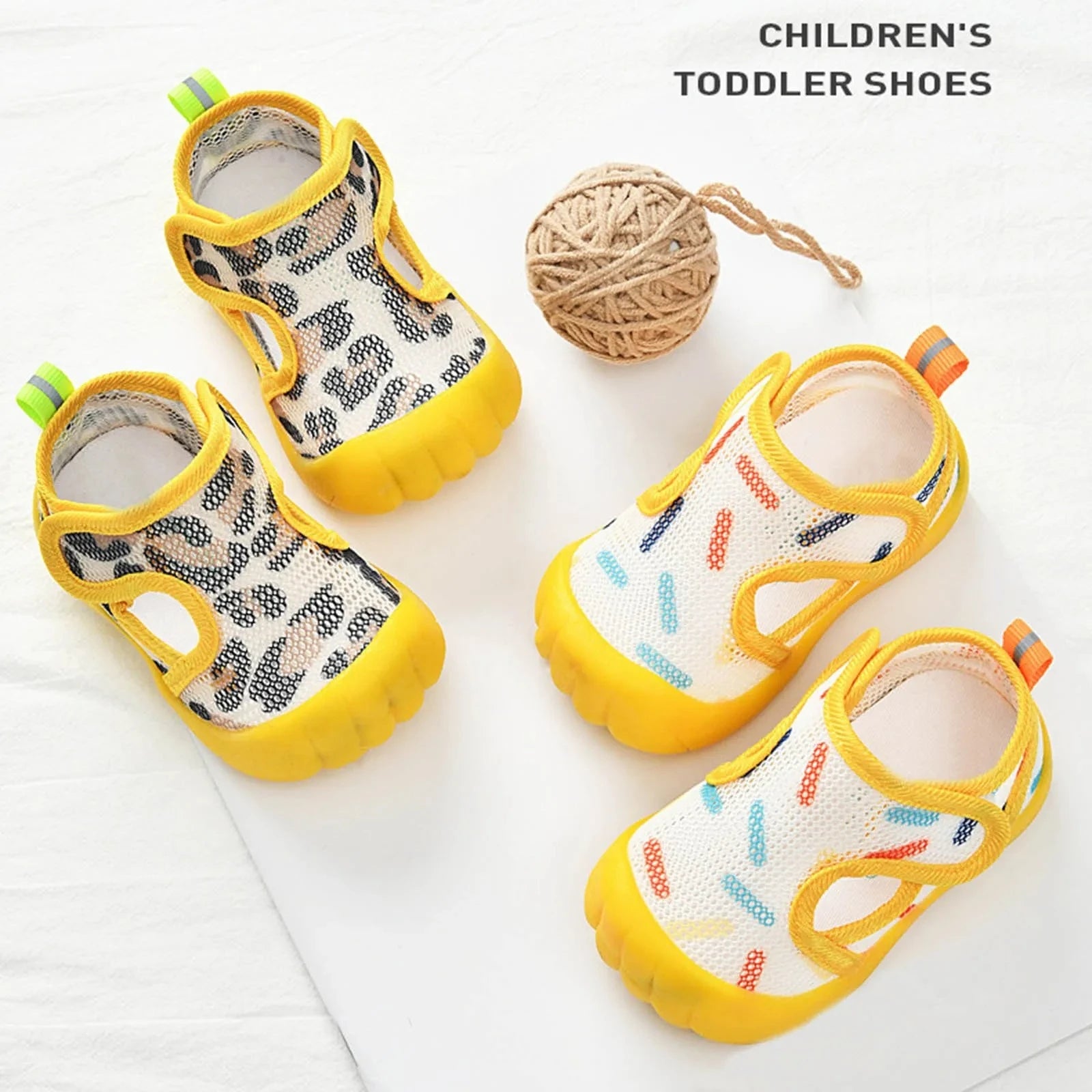 Yellow mesh toddler water shoes with colorful print and velcro strap on beige background
