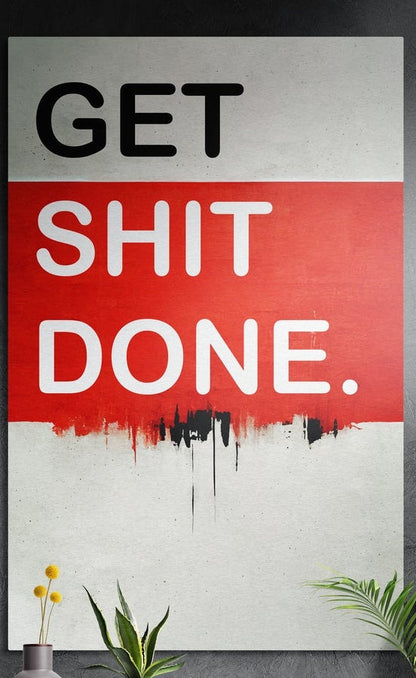 Red band drip Get Sh*t Done brushed aluminum wall art on a dark textured wall above potted plants