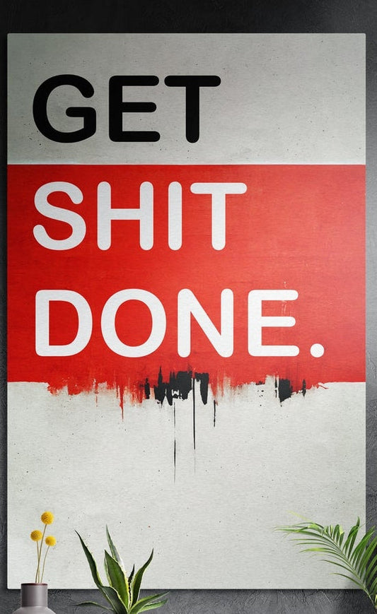 Red band drip Get Sh*t Done brushed aluminum wall art on a dark textured wall above potted plants