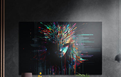 Woman's face in colorful glitch streaks, brushed aluminum wall art on a dark gray wall above a vase and yellow flowers