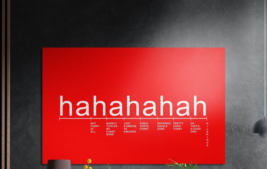 Red laughter scale typography brushed aluminum wall art on a dark textured wall above a vase and plants
