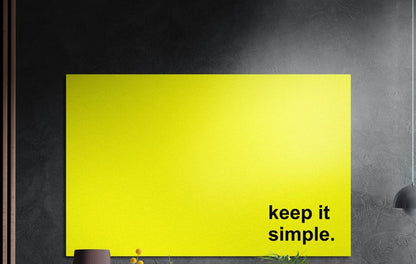 Keep it simple black text on yellow brushed aluminum wall art on a dark textured wall above potted plants