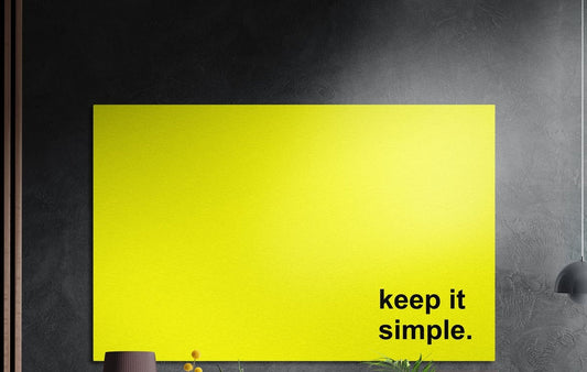 Keep it simple black text on yellow brushed aluminum wall art on a dark textured wall above potted plants