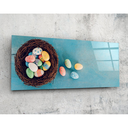 Easter eggs in a nest panoramic glass wall art on a pale concrete wall, angled to show the glossy surface