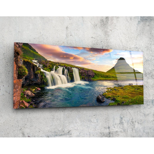Waterfall and cone mountain panoramic glass wall art angled on a pale concrete wall