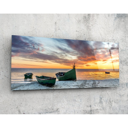 Fishing boats at sunset beach glass wall art on a pale concrete wall