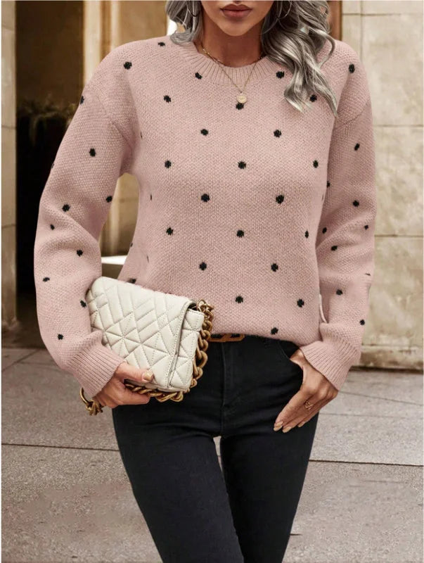 blush-pink knit pullover with black embroidered dots, paired with black pants and a cream quilted chain-strap bag