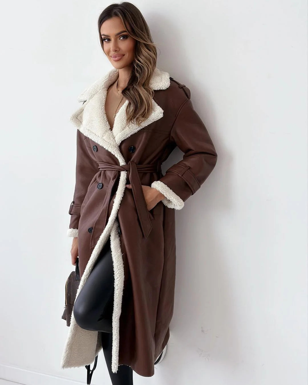 brown faux leather coat with white shearling trim on model
