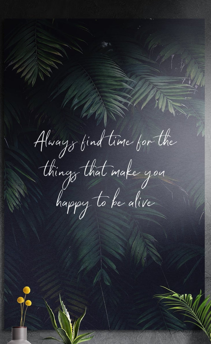 Find time script quote over palm leaves brushed aluminum wall art on a gray wall above yellow flowers