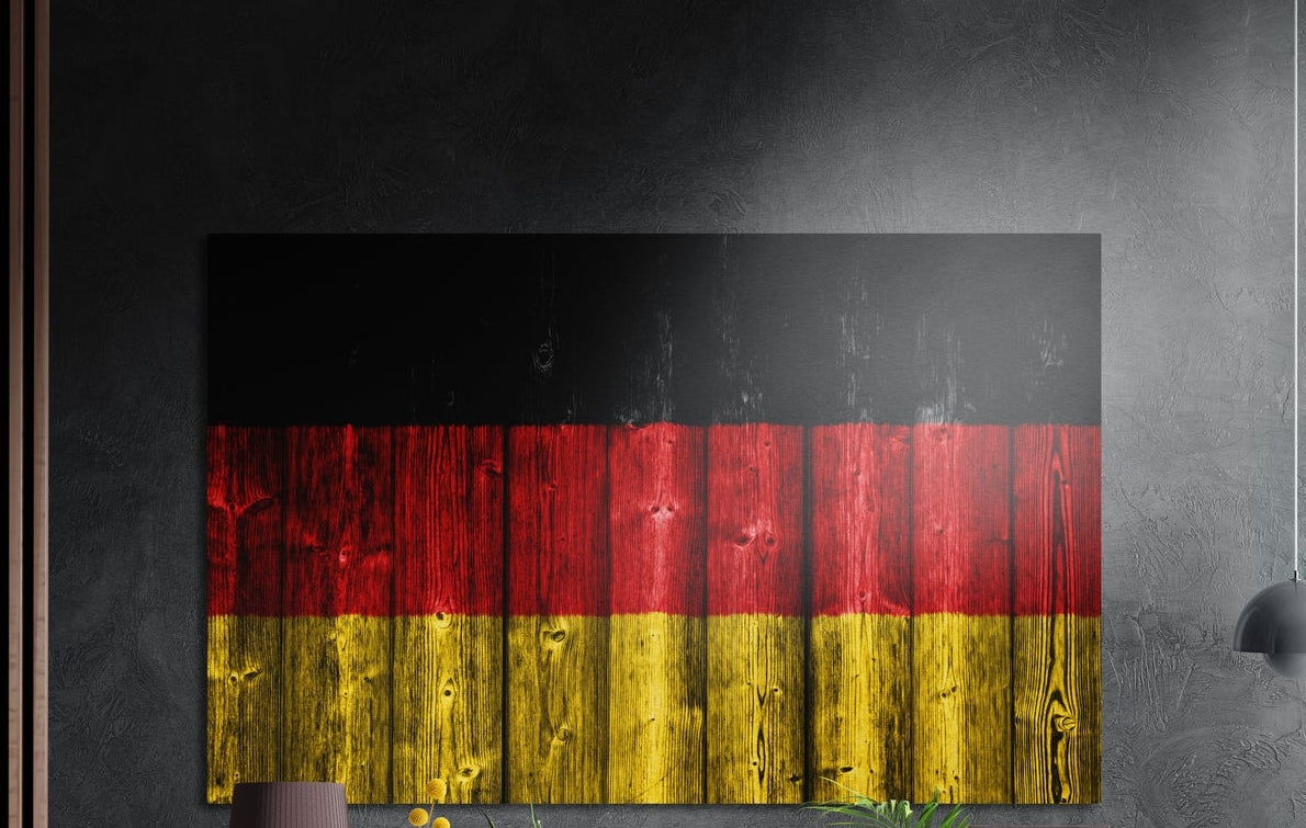 Germany flag in black, red and gold over vertical wood planks, brushed aluminum wall art on a dark gray wall by wood slats