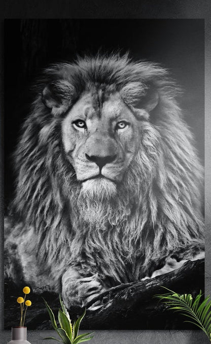 Black and white male lion resting on a log, brushed aluminum wall art on a gray wall above yellow flowers