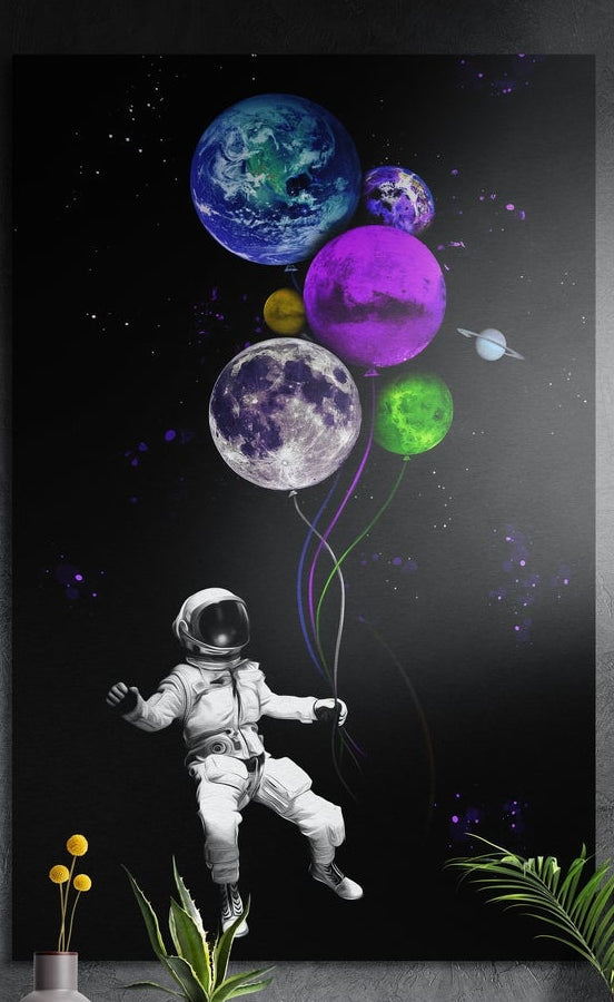 Astronaut with planet balloons brushed aluminum wall art on a gray concrete wall above small plants