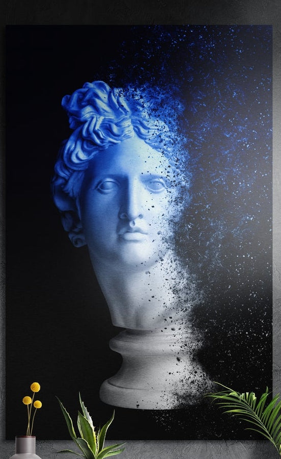Blue bust dissolving into particles brushed aluminum wall art on a dark wall above yellow flowers and plants